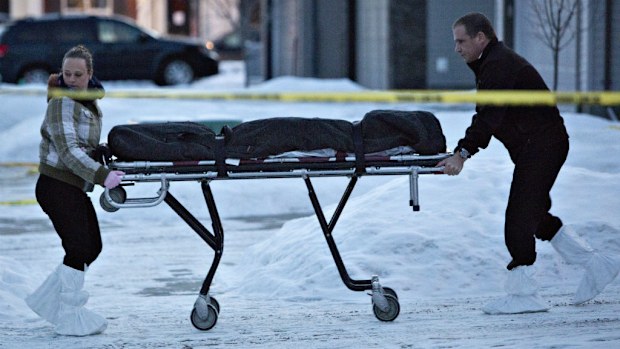 The body of a victim is carried out of a north Edmonton home in Alberta, Canada. (AAP)