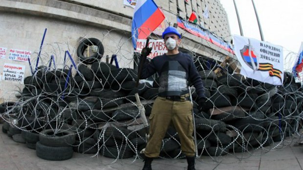 A rebel guards the front of the Donetsk Republic headquarters, after the rebel group seized control of the east Ukraine region. Picture: Kiev Post