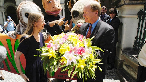Conservation Council coordinator Felicity Wishart (left) presents then-Queensland Premier Peter Beattie a bunch of flowers at a Wilderness Society Rally in Brisbane in 2003. (AAP)