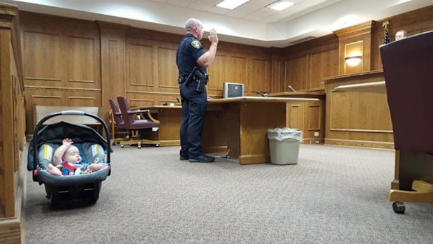 A US police department has captured the moment a baby has mimicked his father's swearing-in ceremony. (Supplied)