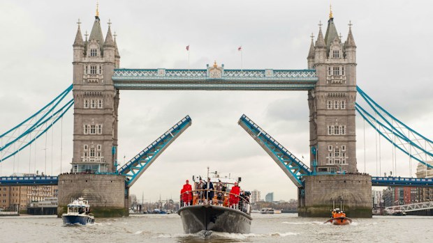 The Havengore barge passes under Tower Bridge in central London, at the head of a procession recreating the journey made 50 years ago carrying the coffin of Sir Winston Churchill. (AAP)