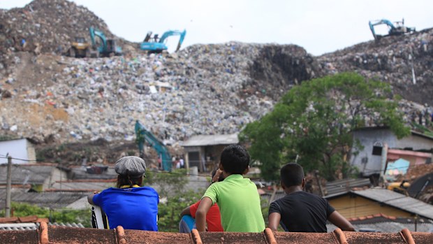 A Sri Lankan boy who survived the garbage dump collapse surveys the damage. (AFP)