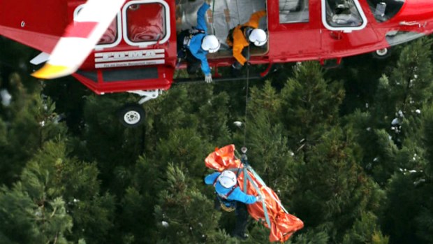 An helicopter airlifts a victim out of the snow in Japan. 9AAP)