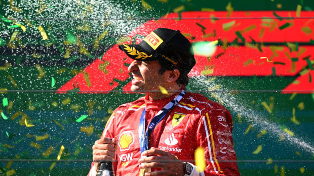 Race winner Carlos Sainz celebrates on the podium.