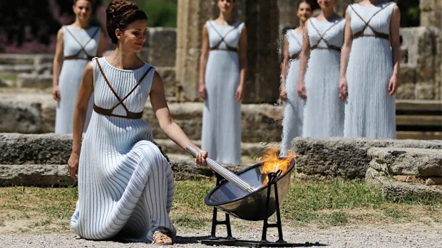 A dancer dressed as High Priestess lights the Olympic flame with a parabolic mirror during the ceremonial lighting of the Olympic flame in Ancient Olympia, Greece. (AAP)