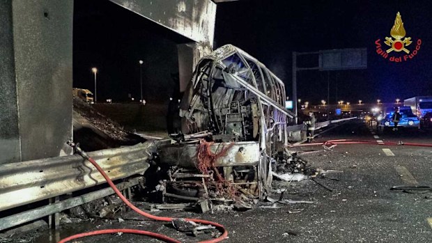 A firefighter sprays water on the burned hulk of a bus that crashed and burst into flames near Verona, northern Italy. (Images: Italian firefighters/ANSA via AP)