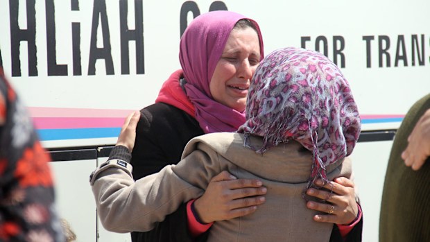 A Syrian woman, wounded in a car bomb blast on April 15 while waiting at a transit point, greets a recently evacuated friend at the rebel-held transit point of Rashidin outside the government-held second city of Aleppo, on April 19, 2017. (AFP)