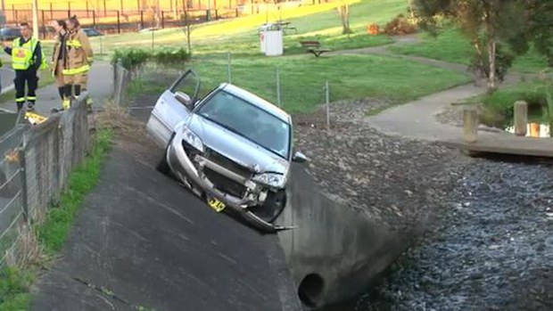 A woman has been rescued from her car which was left hanging over a storm drain after an accident in Seven Hills. (9NEWS)
