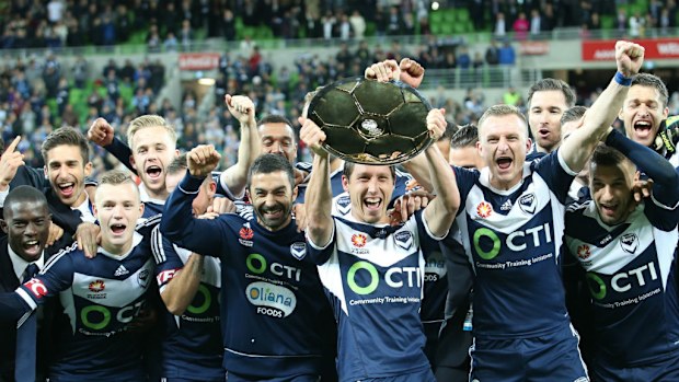 Melbourne Victory captain Mark Milligan and the team hold up the Premier plate after finishing top of the league. (AAP)