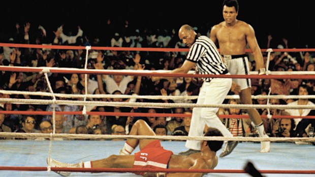 Muhammad Ali, right, stands back as referee Jack Clayton calls the count over the fallen George Foreman. (AAP)