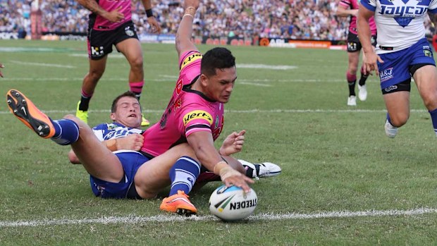 Dallin Watene Zelezniak of the Penrith Panthersbeats the tackle of Josh Morris of the Canterbury Bankstown Bulldogs to score during their round 1 NRL match. (AAP)