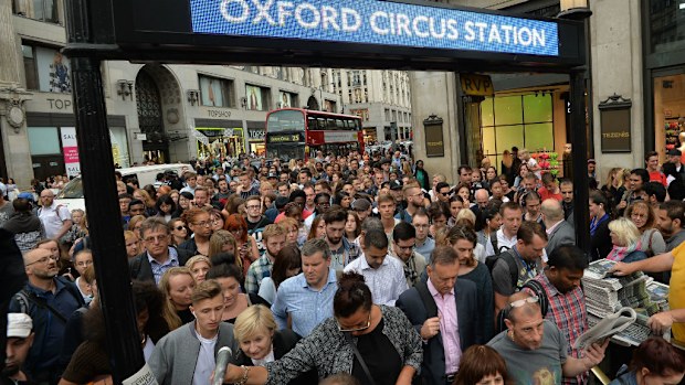 People queue at an entrance to Oxford Circus station in London before the strike starts.