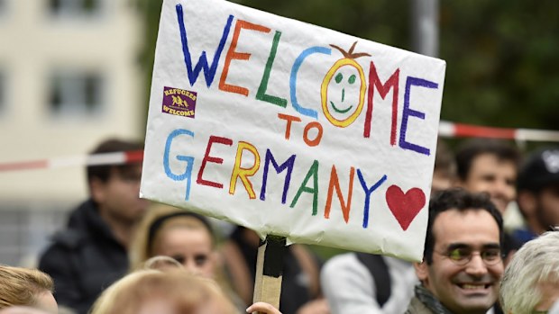 People welcome refugees with a banner reading 'welcome to Germany' in Dortmund, Germany.
