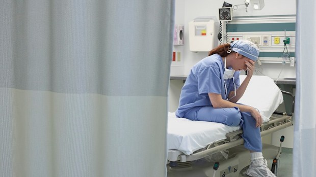 Sad nurse sitting on a hospital bed