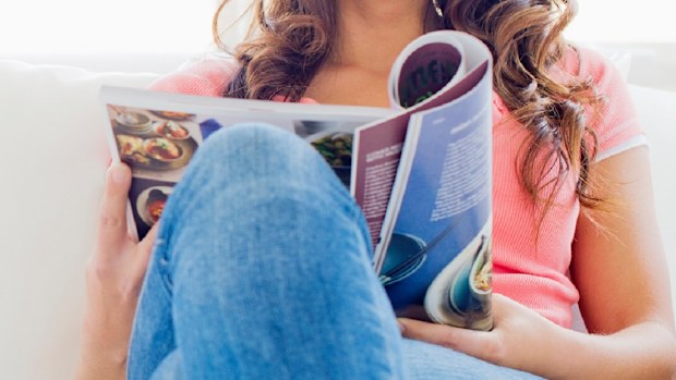 Woman relaxing on a lounge with a magazine