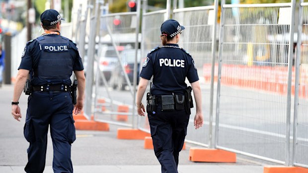 Police patrol the perimeter fence outside the Brisbane Convention and Exhibition Centre. (AAP)