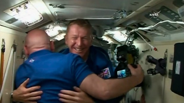 Tim Peake hugs NASA astronaut Scott Kelly after arriving at the ISS. (NASA)