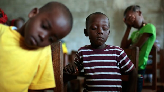 Children praying during Sunday service at the Bridgeway Baptist Church in the St. Paul Bridge neighborhood in Liberia. (AAP)