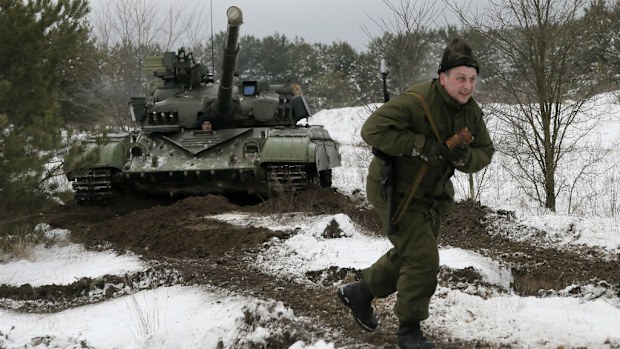 A Ukraine soldier and tank take part in training drills. (AAP)