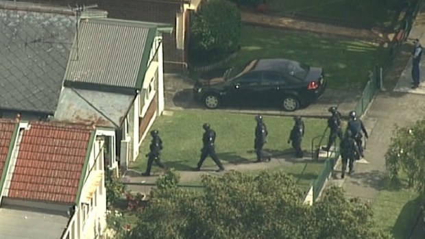 Armed officers enter the Lakemba home. (9NEWS)