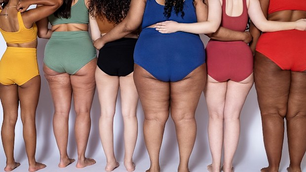 Rear view of group of women with different body type in underwear standing together on white background. 