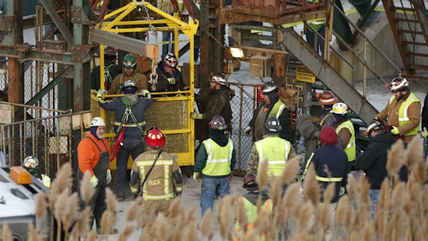 The fourth group of workers emerge from an elevator. (Simon Wheeler/The Journal via AP)