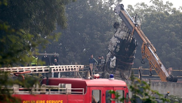 Indian officials inspect the wreckage of a twin-engine turboprop aircraft that crashed near Delhi airport. (AAP)