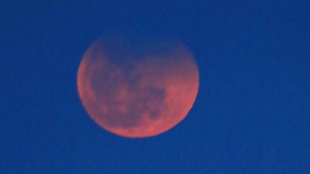 The last time the moon turned a red colour was during an eclipse in April. In this photo taken in Tokyo, Japan on April 15, 2014 the moon has turned a deep orange shortly after moonrise. (AP)