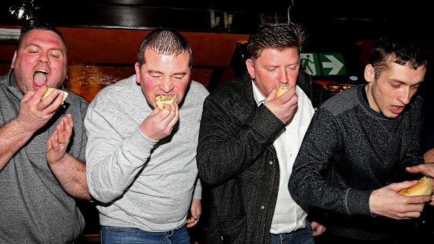 Contestants take part in the World Pie Eating Championships at Harry's Bar in Wigan. (AAP)