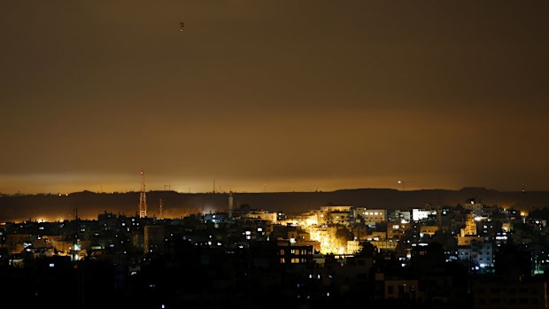 The sky is lit by flares and explosions in the northern Gaza Strip, early Friday, July 18, 2014. (AAP)