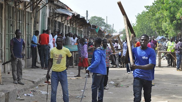 Vigilantes barricade the road following an explosion at a market in Maiduguri, Nigeria. (AAP)