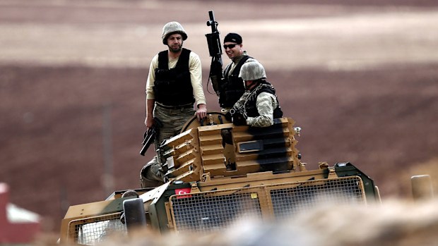 Turkish soldiers on a hill after an airstrike on Kobane, Syria. (AAP)