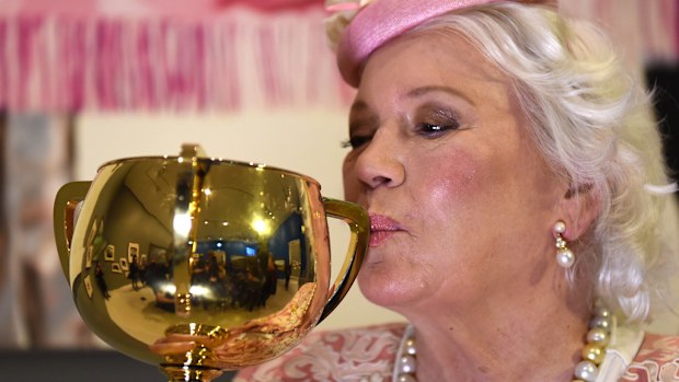The 1930 - 1980 Melbourne Cup trophy is kissed by its owner Lady Susan Renouf as it goes on display at The Horse exhibition at the National Gallery of Victoria. (AAP)