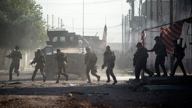Iraqi Special Forces 2nd division soldiers come under fire from ISIS while running across an intersection = in the Karkukli neighbourhood of Mosul on November 13, 2016. (AFP)