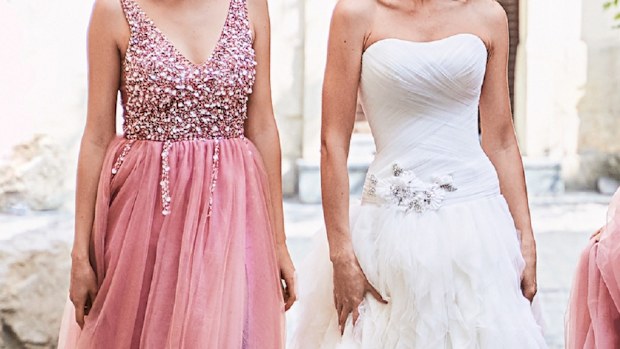 bride standing with bridesmaid wearing a pink dress