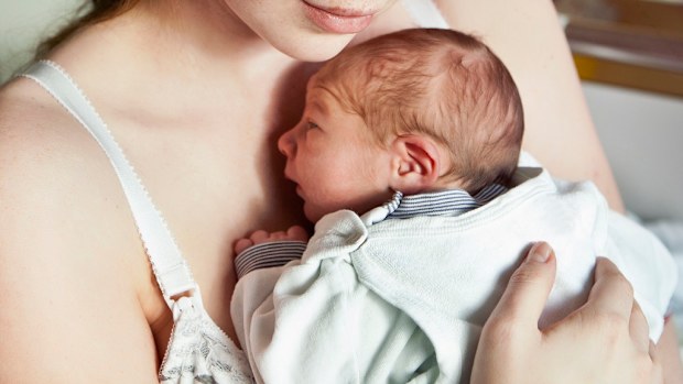 Tired mother holding newborn baby