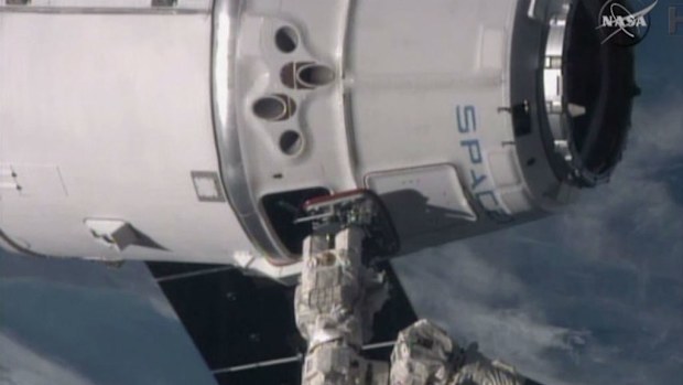 The International Space Station's robotic arm reaches for the SpaceX Dragon spacecraft as the soar more than 260 miles above the Mediterranean. (NASA)