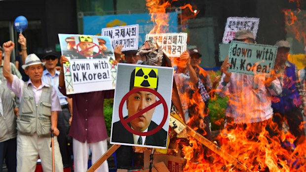 South Korean conservative activists set fire to a portrait of North Korean leader Kim Jong-Un during a protest denouncing North Korea's nuclear test in Seoul on September 10, 2016. (AFP)