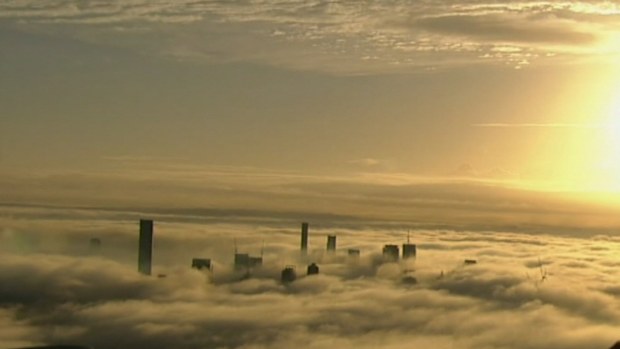 The sun peaks over the top of a heavy blanket of fog in Brisbane.