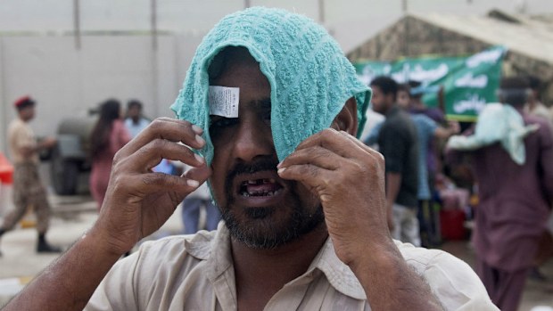 A man covers his head with a wet towel to avoid heatstroke in Karachi, Pakistan. (AAP)