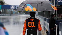 Oscar Piastri walks back to the garages in the rain.