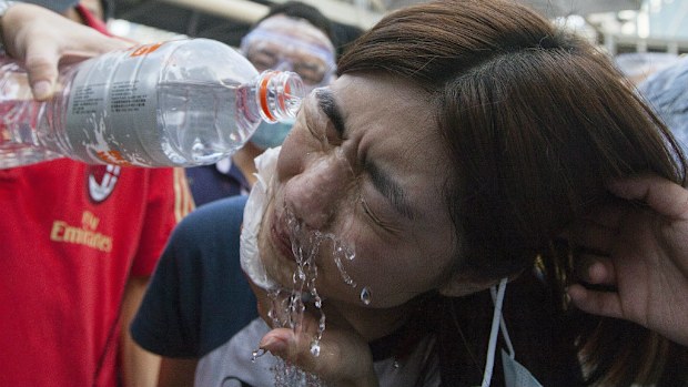 A protester gets tear gas washed from her eyes in Hong Kong. (AAP)
