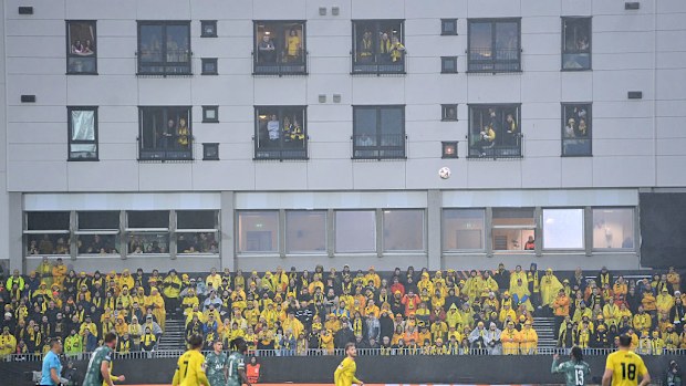 Fans of FK Bodo/Glimt watch the game from nearby apartments.