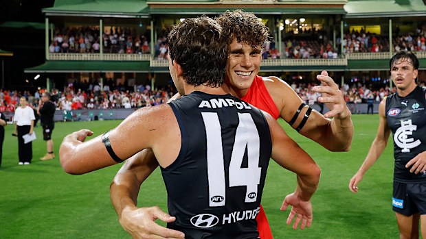 Oliver Florent and Charlie Curnow embrace.
