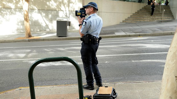 A police officer operates a speed radar. (AAP Image/Dave Hunt)