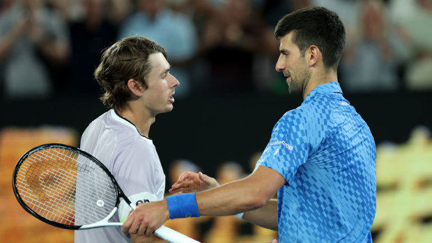 Alex de Minaur and Novak Djokovic embrace at the net. Australian Open.