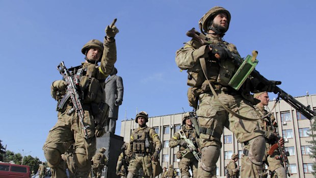 Ukrainian soldiers walk outside the city government headquarters in the city of Slovyansk, eastern Ukraine. (AAP)