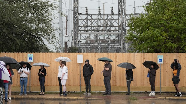 Rain pours down while voters are waiting in line to cast their vote on election day at West Gray Multiservice Center in Houston. 