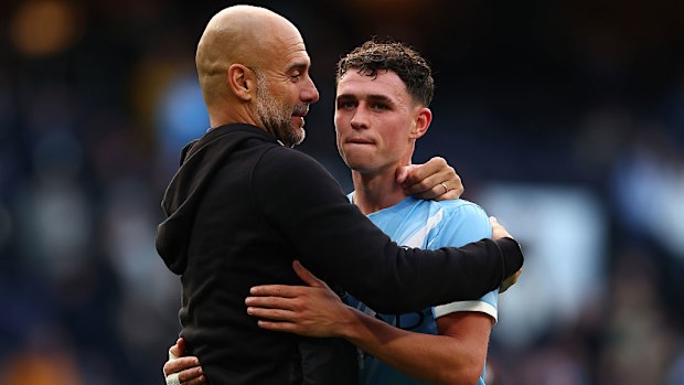 Manchester City manager Pep Guardiola celebrates the 3-0 win with Phil Foden.