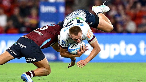 Joey Walton of the Waratahs is tackled by Josh Flook of the Reds.